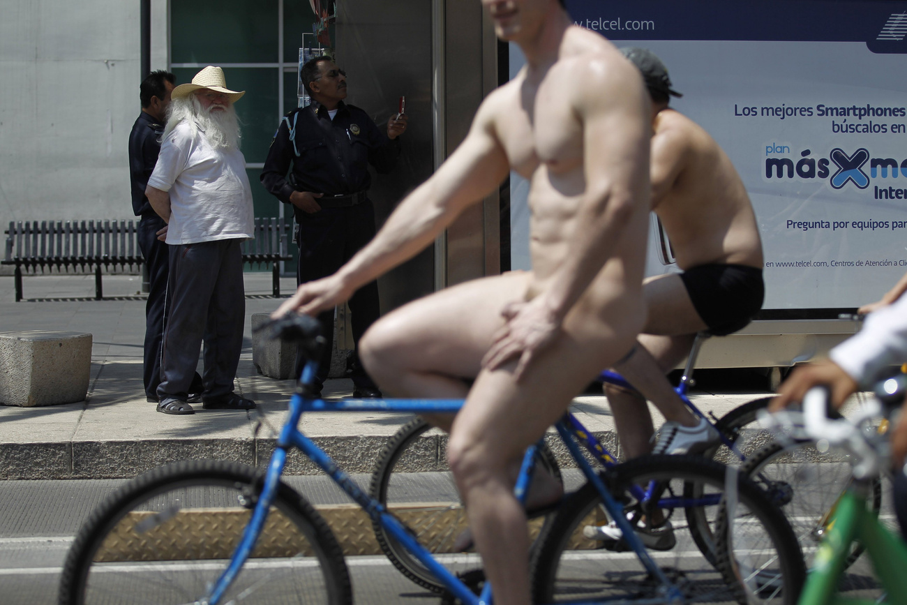 Ezt a görög nudistát is kerékpár nélkül fotózták le, de a hátán a felirat egyértelmű: „Az IMF bekaphatja, inkább tekerjünk!