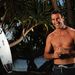 Ausztrália szörfbajnoka az óceánparton pózol