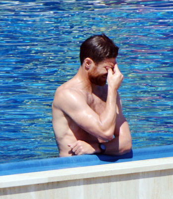 Alonso a medence szélén könyököl