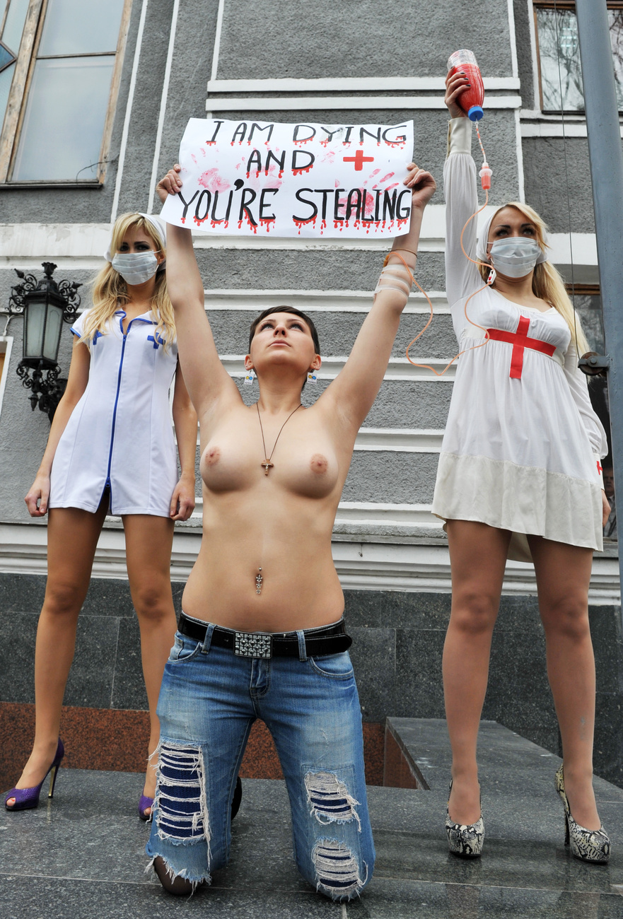Rendőrök avatkoznak be a FEMEN tüntetésén - az aktivisták Kijevben protestálnak Viktor Janukovics elnök kormányának demokrácia-sértései ellen. A rendezvény egybeesett egy nemzetközi jótékonysági konferenciával, amelyet a csernobili atomerőmű maradványainak biztonságosabbá tételéért szerveztek.